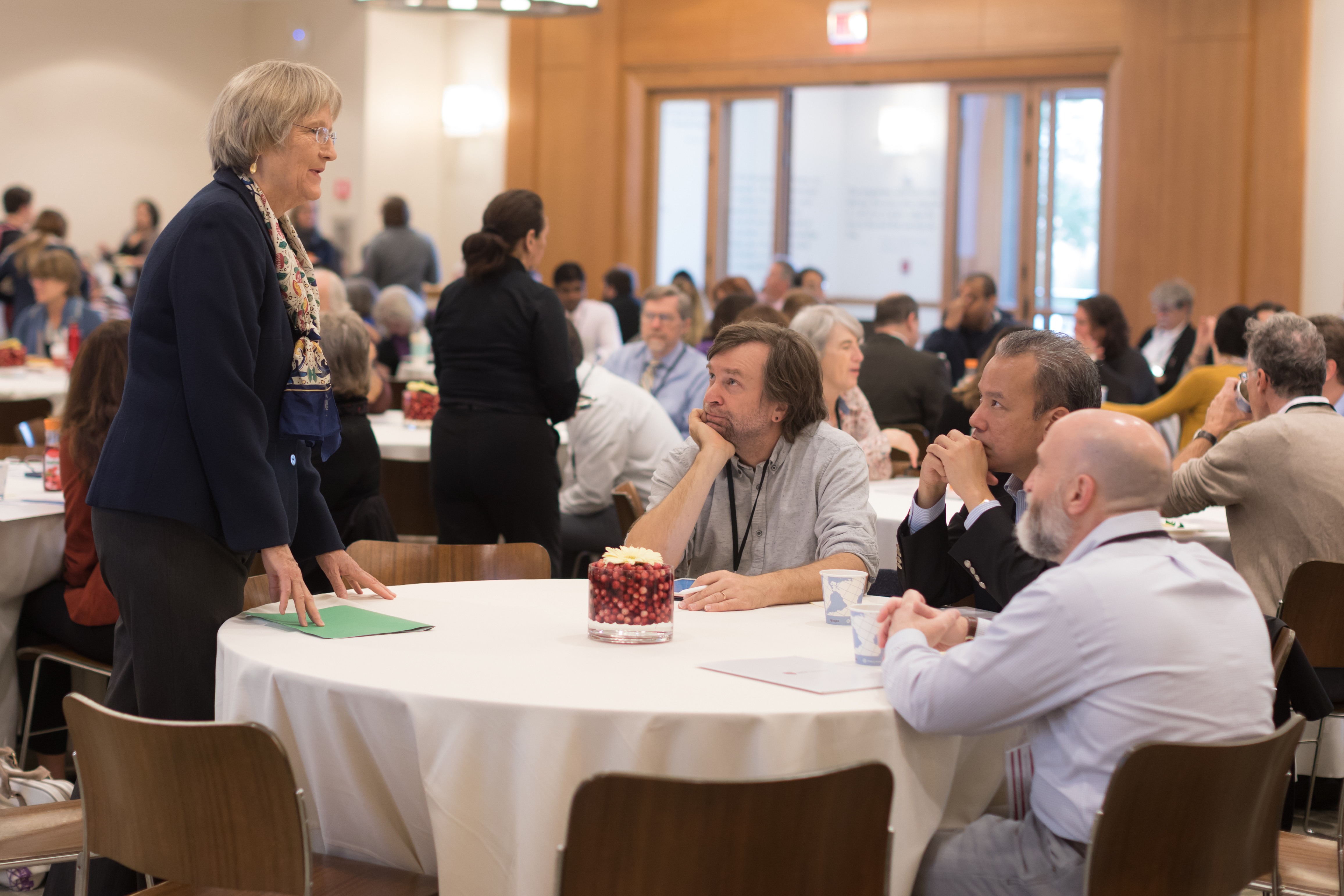 President Drew Faust speaks engages with some faculty members prior to taking the stage to provide welcome remarks to conference attendees