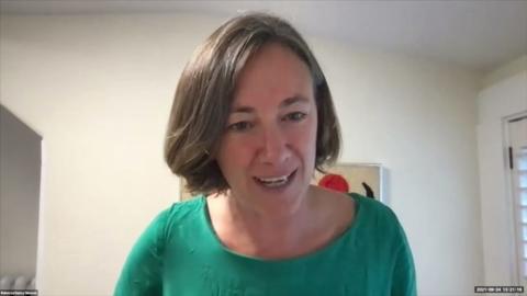 A woman with short brown hair wearing a green top