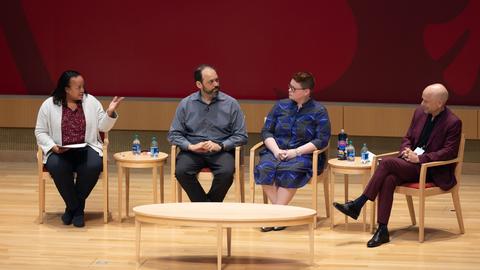 Harvard educators sitting on a well lit stage at HBS
