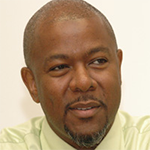 Cecil Adderley looking curiously to the right with a small smirk. 