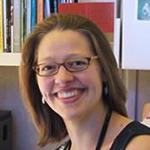 Odile Harter smiling in her red colored glasses