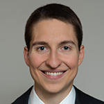 Michael Kochis smiling brightly in a black blazer