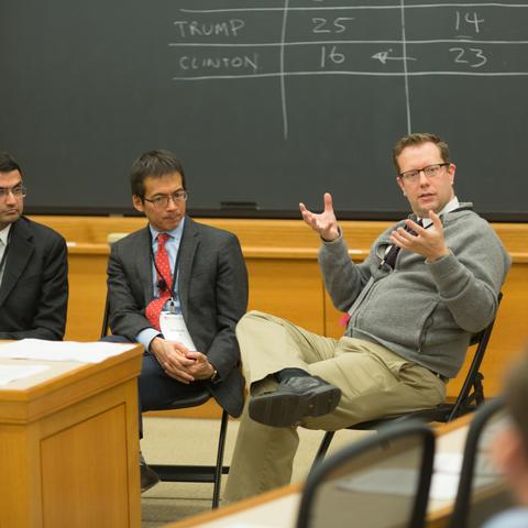 HILT 2016 panelist holding a discussion in a Harvard classroom with chalkboards.