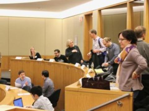 People sitting in a sunny lecture hall. 