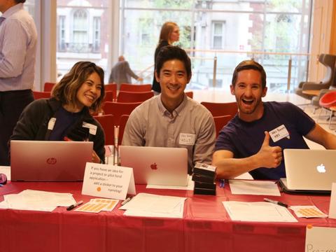 Harvard staff sitting at a red rectangle table.