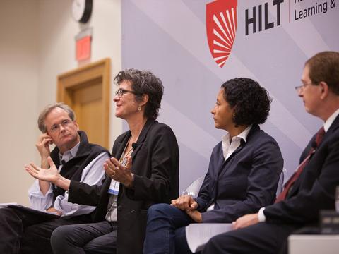 A panel of educators on stage