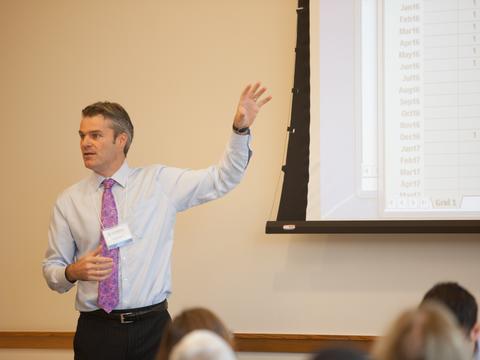 A man standing next to a projector