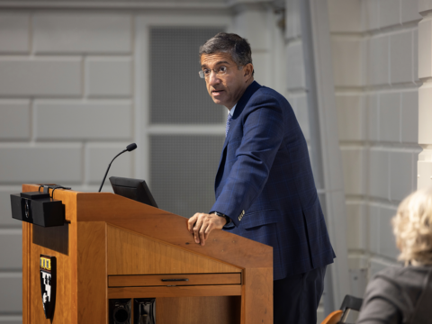 Bharat Anand standing at a podium