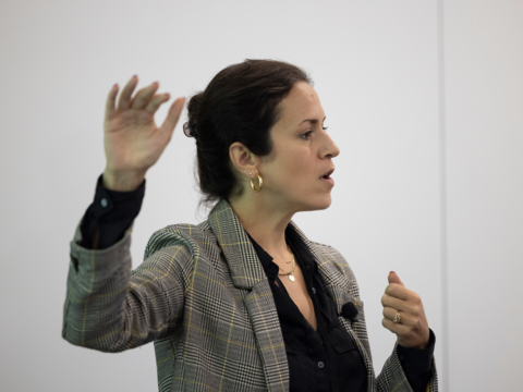 A woman with her arm raised at a 90 degree angle