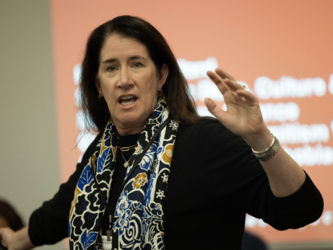 A woman holding her hand up while speaking
