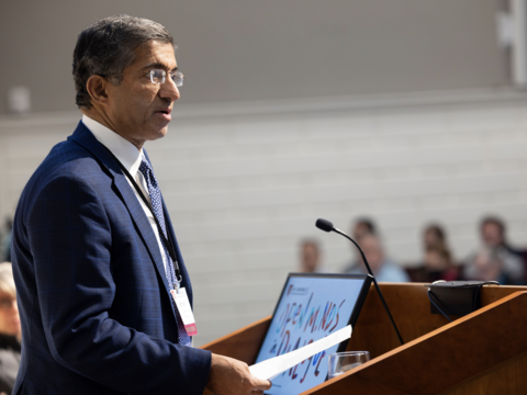 Bharat Anand standing at a podium