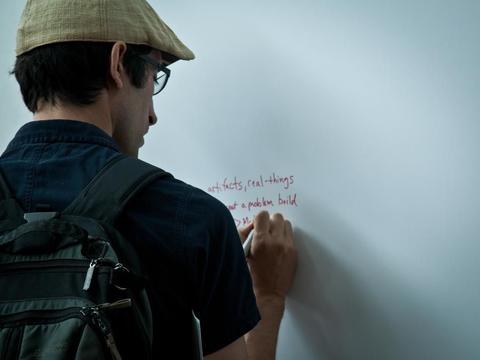 A man writing on a whiteboard 