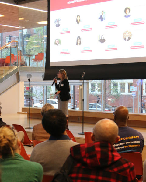Presenter at HILT event standing on stage.