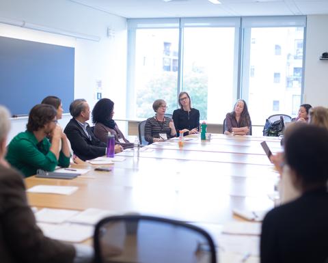 A room with a large conference table surrounded by HILT 2016 Conference attendees. 