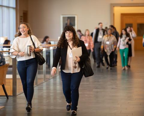 People walking in a long sunny hallway