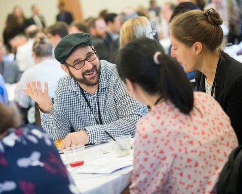 HILT Conference attendees networking at round tables.