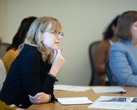 A woman with glasses wearing a black long sleeved shirt