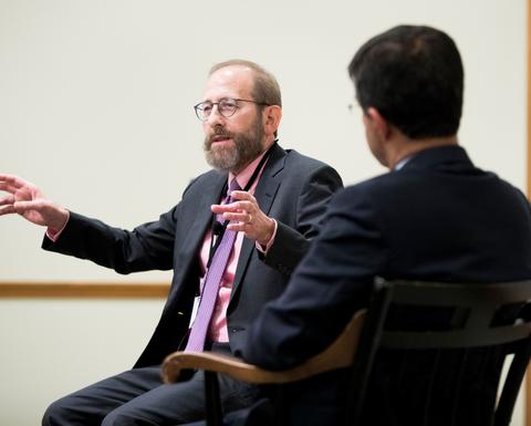 A man with a light brown beared giving a speech.
