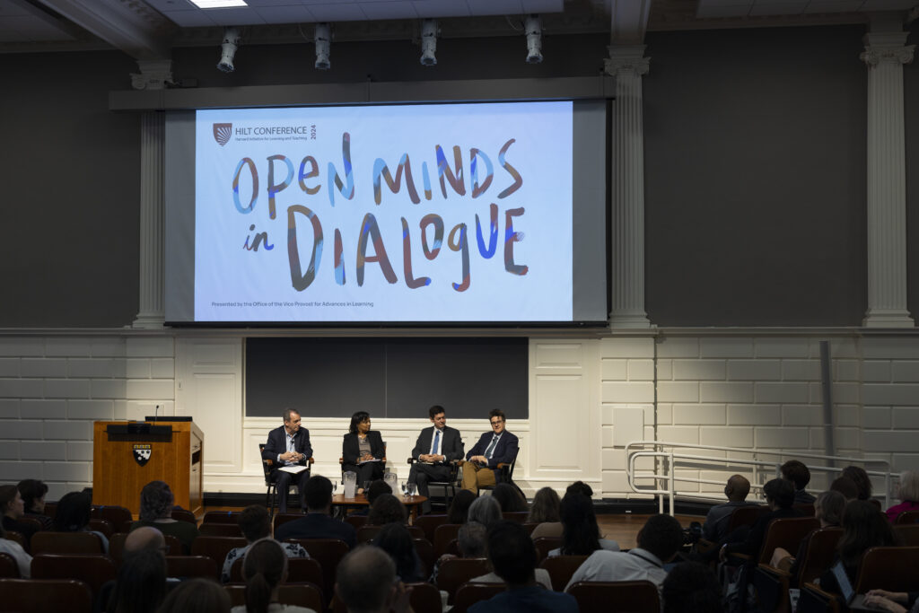 A video projector displaying the colorful title of the 2024 HILT Conference &quot;Open Minds in Dialogue&quot;&quot;